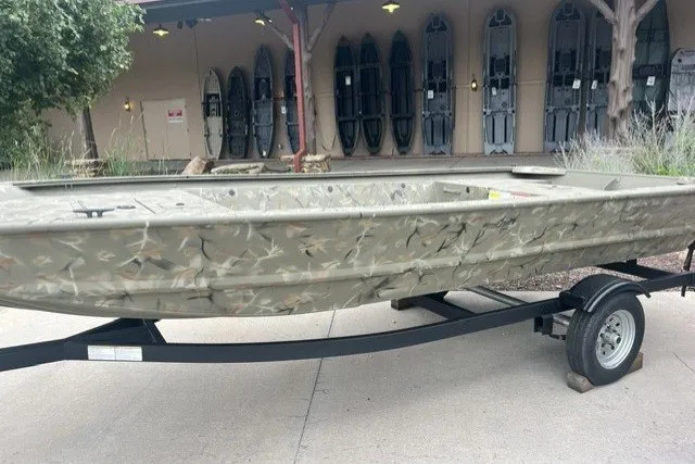The Image of 2025 Tracker Grizzly 1648 Jon boat on trailer, camo design, outdoor display. - 22