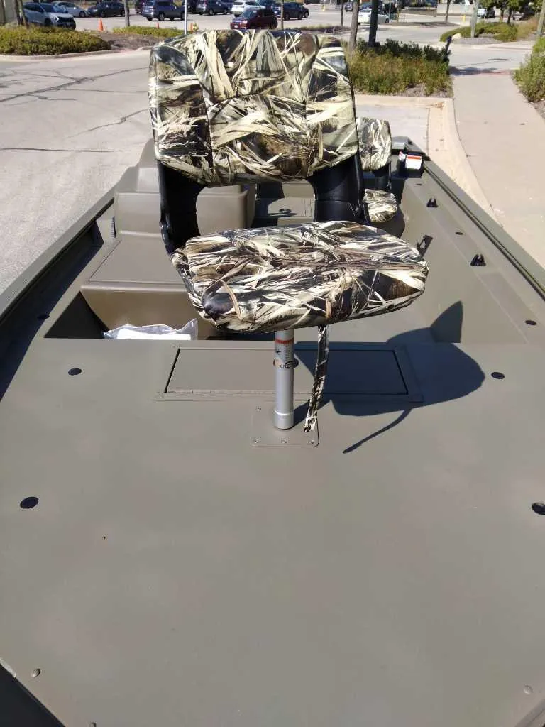Slide: The Image of 2025 Tracker Grizzly 1754 SC boat with camo seats on a sunny day. - 3