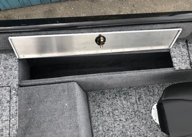 Slide: The Image of 2025 Tracker Pro Guide V-175 Combo boat storage compartment with gray carpet interior. - 16