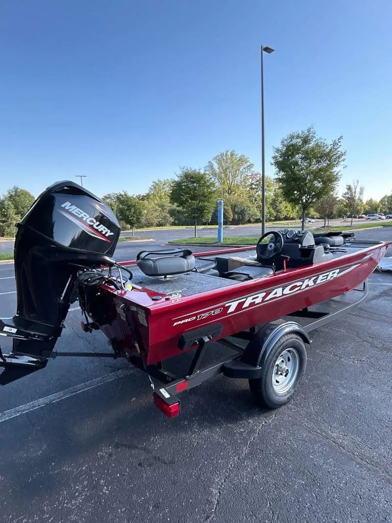 Slide: The Image of 2025 Tracker Pro 170 boat with Mercury engine, parked outdoors on a sunny day. - 3