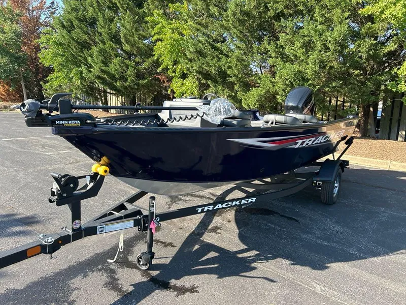 Slide: The Image of 2025 Tracker Pro Guide V-16 SC boat on trailer, parked outdoors. - 2