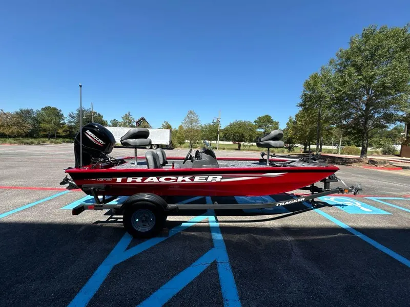 Slide: The Image of 2025 Tracker Pro 170 boat in parking lot, vibrant red color, clear blue sky. - 2