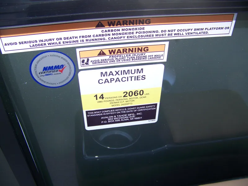 Slide: The Image of Warning labels and capacity information on a 2025 Avalon Ven25VRB boat. - 8