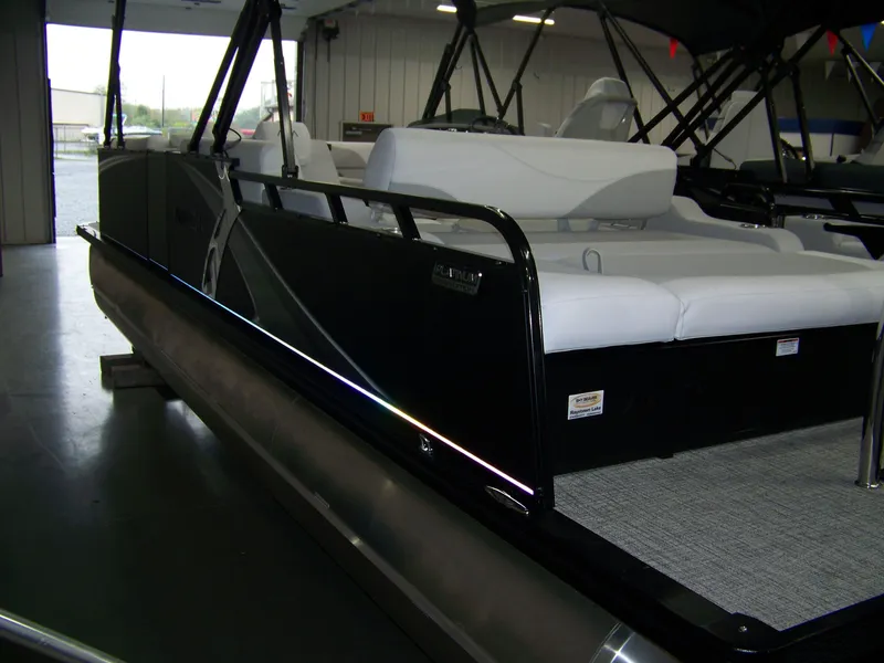 Slide: The Image of 2025 Avalon LSZ25VRB pontoon boat with sleek black exterior and white seating in a showroom. - 11