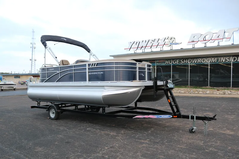 Slide: The Image of 2025 Bennington 20 SSRCX pontoon boat on trailer outside showroom. - 1