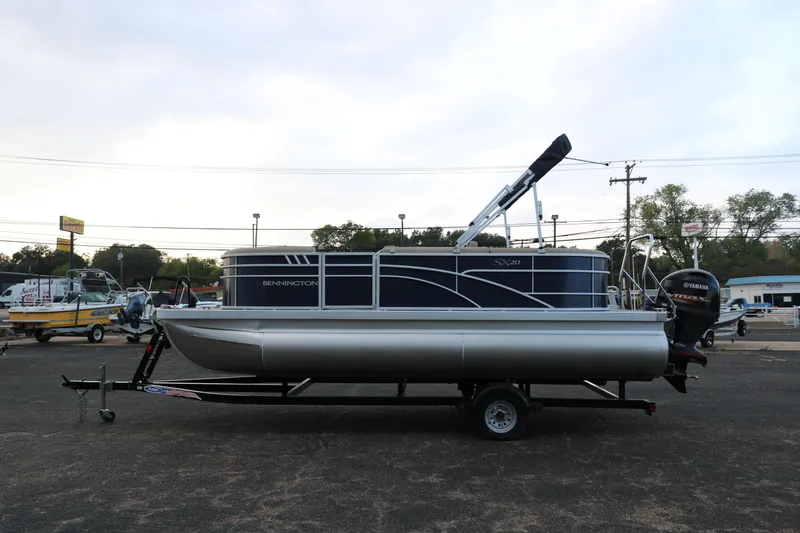Slide: The Image of 2025 Bennington 20 SSRCX pontoon boat on trailer in parking lot. - 4