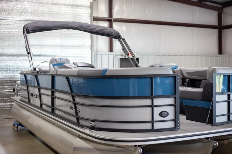 Slide: The Image of 2025 Trifecta 24E CS3 pontoon boat in a warehouse setting. - 2