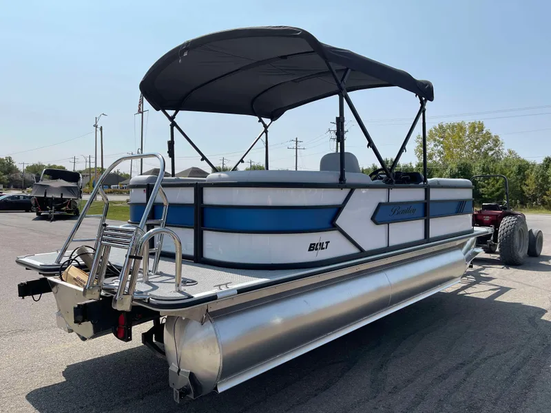Slide: The Image of 2025 Bentley Pontoons Bolt 223 with canopy, parked on a trailer in a sunny lot. - 4