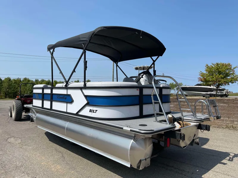 Slide: The Image of 2025 Bentley Pontoons Bolt 223 with canopy on trailer, parked outdoors. - 6