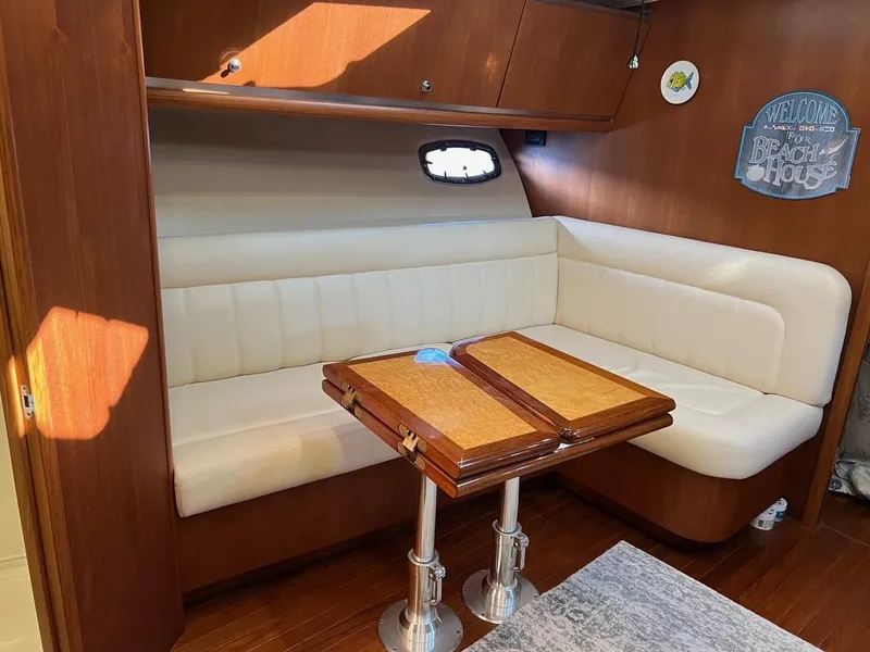 Slide: The Image of 2005 Tiara Yachts 4200 Open interior with white leather seating and wooden table. - 15
