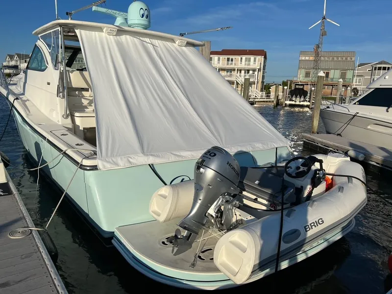 Slide: The Image of 2005 Tiara Yachts 4200 Open docked with inflatable boat, marina background. - 5