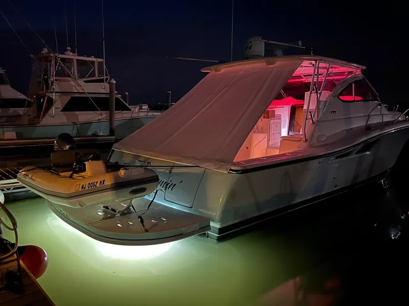 Slide: The Image of 2005 Tiara Yachts 4200 Open with illuminated deck at night, docked in marina. - 6