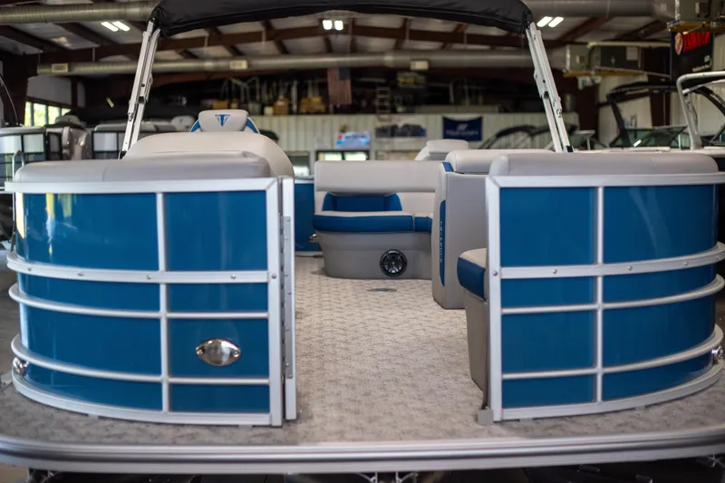 Slide: The Image of 2025 Trifecta 24TRFC LE pontoon boat with blue and white interior in showroom. - 9