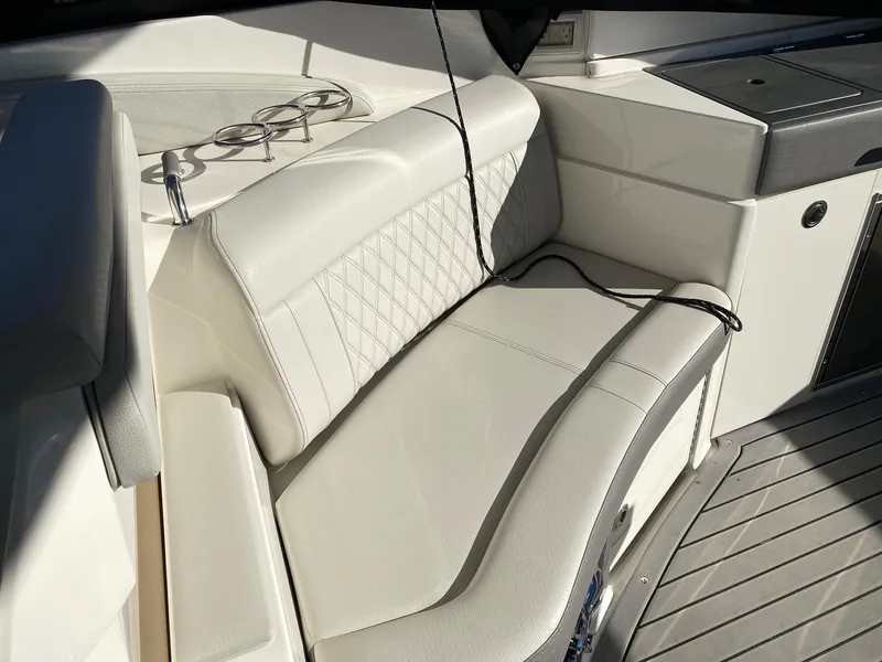 Slide: The Image of 2020 Sea Ray SLX 350 boat interior with white leather seating and cup holders. - 11
