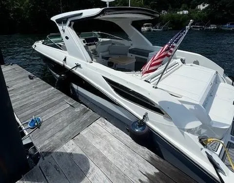 Slide: The Image of 2020 Sea Ray SLX 350 boat docked with American flag on stern. - 2