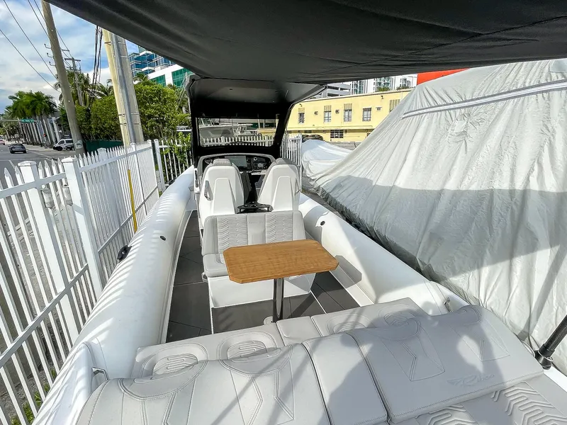 Slide: The Image of 2025 Ribco Venom 30 boat interior with seating and table under canopy. - 12