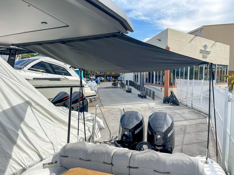 Slide: The Image of 2025 Ribco Venom 30 boat with dual engines, docked under a canopy. - 13