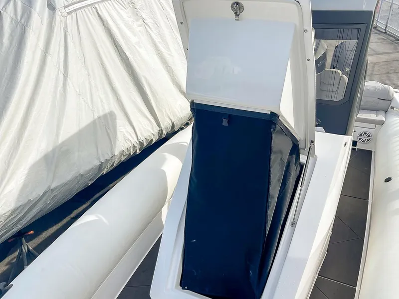 Slide: The Image of 2025 Ribco Venom 30 boat storage compartment open, showcasing interior space. - 26
