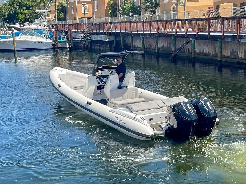 Slide: The Image of 2025 Ribco Venom 30 boat with dual engines cruising in a marina. - 5