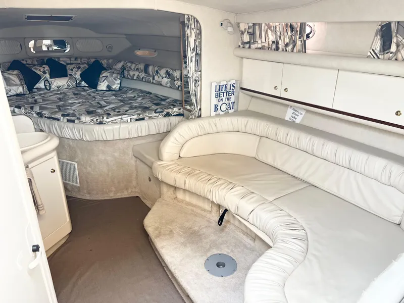 Slide: The Image of 1997 Sea Ray 330 Sundancer Cruiser interior with cozy seating and bed area. - 10