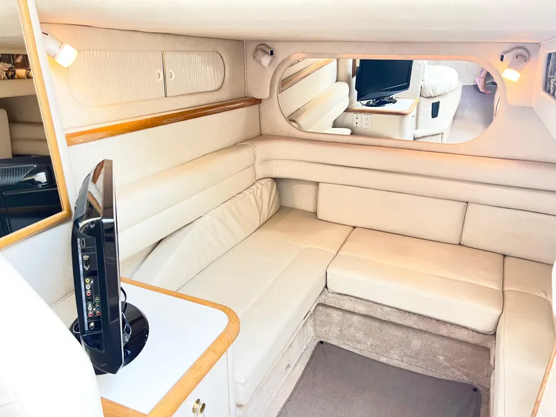 Slide: The Image of Interior of 1997 Sea Ray 330 Sundancer Cruiser with beige seating and TV. - 12