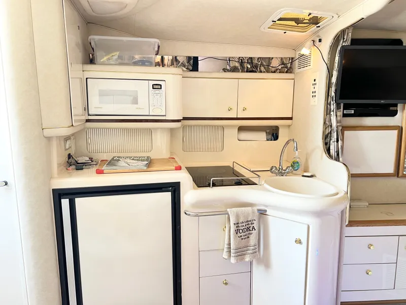 Slide: The Image of Interior of 1997 Sea Ray 330 Sundancer Cruiser with kitchenette and modern amenities. - 15