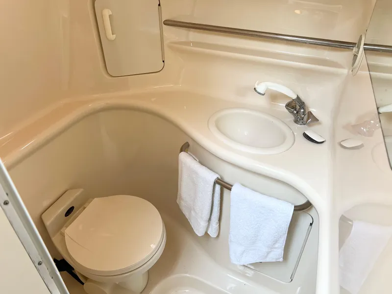 Slide: The Image of 1997 Sea Ray 330 Sundancer Cruiser bathroom with sink, toilet, and towel rack. - 19