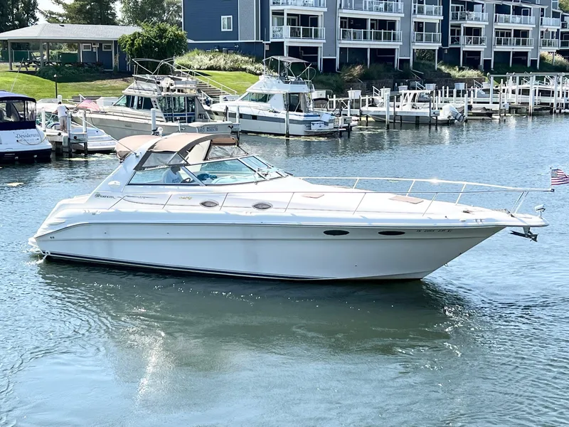 Slide: The Image of 1997 Sea Ray 330 Sundancer Cruiser docked in a marina, surrounded by other boats. - 25
