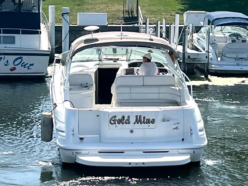 Slide: The Image of 1997 Sea Ray 330 Sundancer Cruiser named "Gold Mine" docked in a marina. - 26