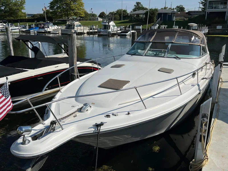 Slide: The Image of 1997 Sea Ray 330 Sundancer Cruiser docked at marina, sunny day, American flag visible. - 3
