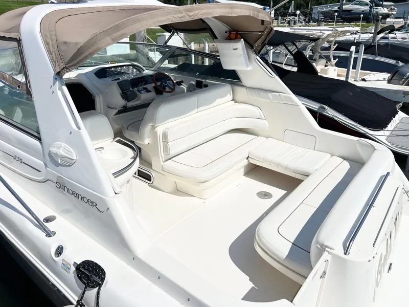 Slide: The Image of 1997 Sea Ray 330 Sundancer Cruiser with white seating and canopy, docked at a marina. - 4