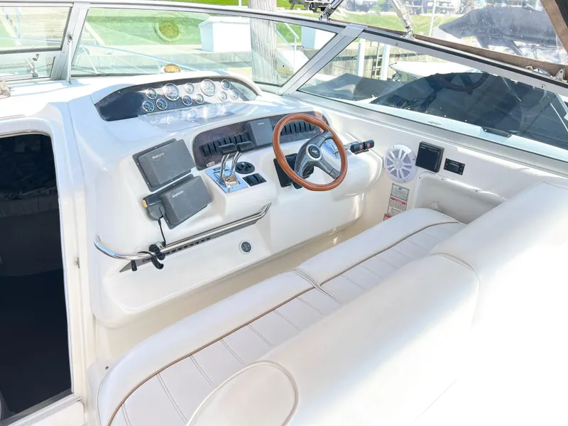 Slide: The Image of 1997 Sea Ray 330 Sundancer Cruiser helm with steering wheel, gauges, and navigation equipment. - 8