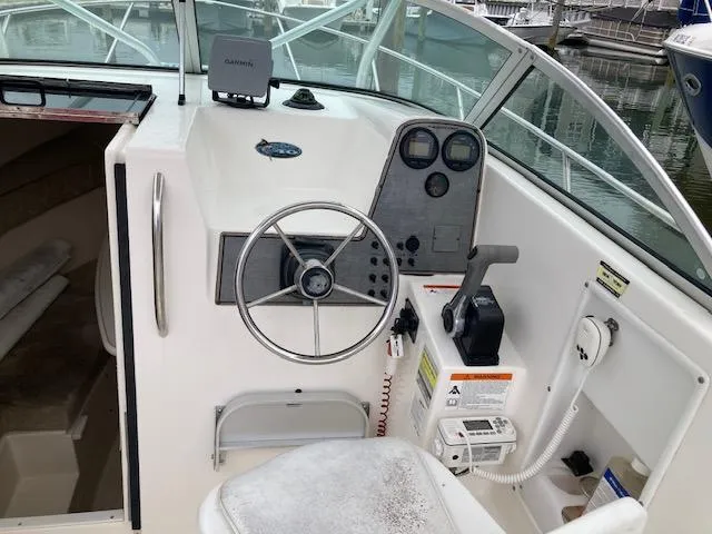 Slide: The Image of 2004 Aquasport 215 Explorer boat cockpit with steering wheel and control panel. - 5