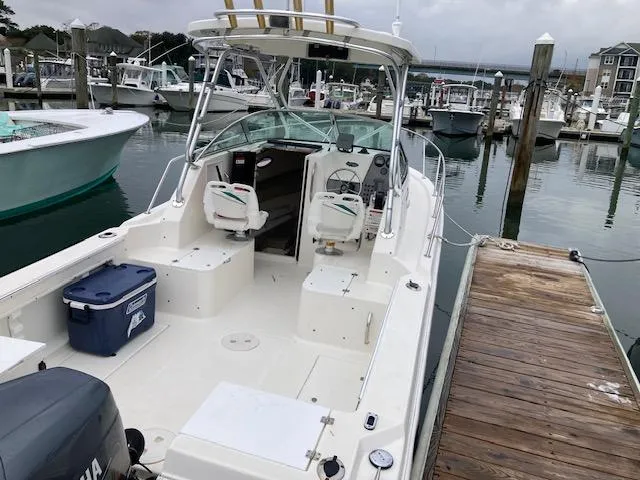 Slide: The Image of 2004 Aquasport 215 Explorer boat docked at marina, featuring spacious cockpit and seating. - 8