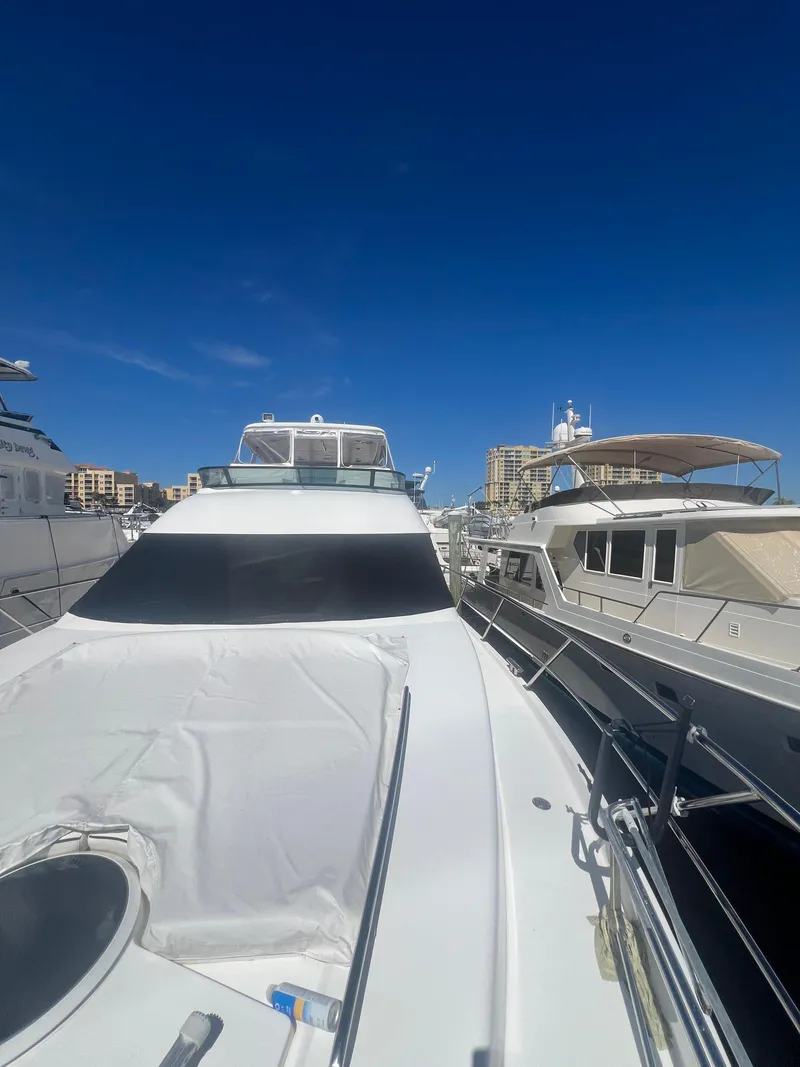 Slide: The Image of 2005 Neptunus 62 Flybridge yacht docked at marina under clear blue sky. - 10