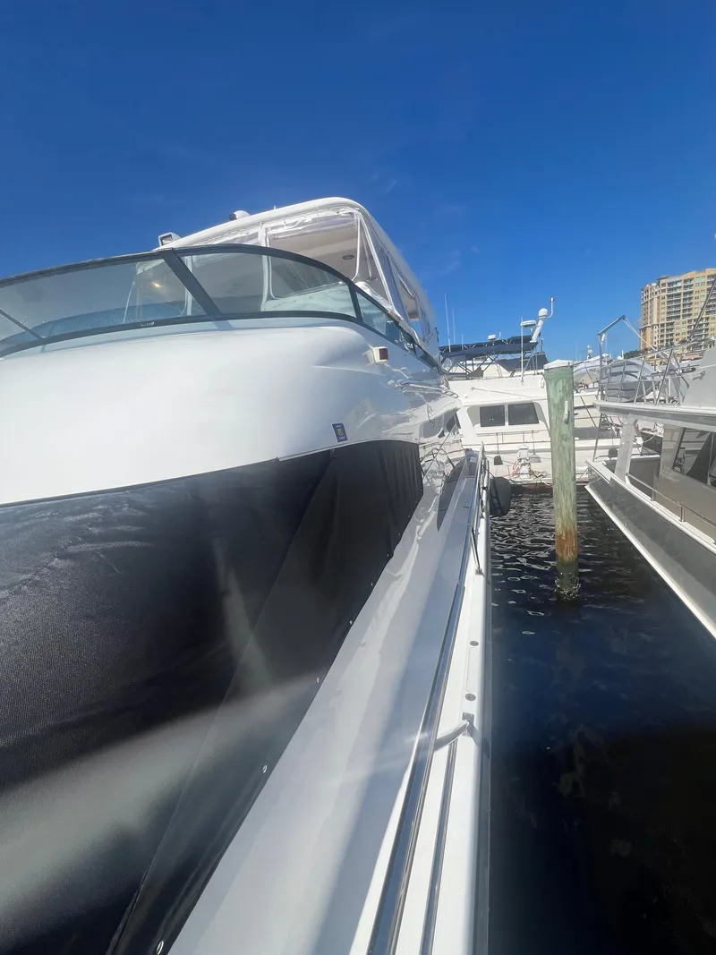 Slide: The Image of 2005 Neptunus 62 Flybridge yacht docked under clear blue sky. - 11