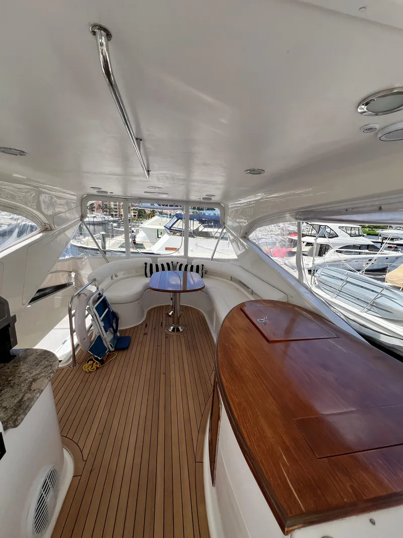 Slide: The Image of 2005 Neptunus 62 Flybridge yacht interior with wood flooring and seating area. - 17