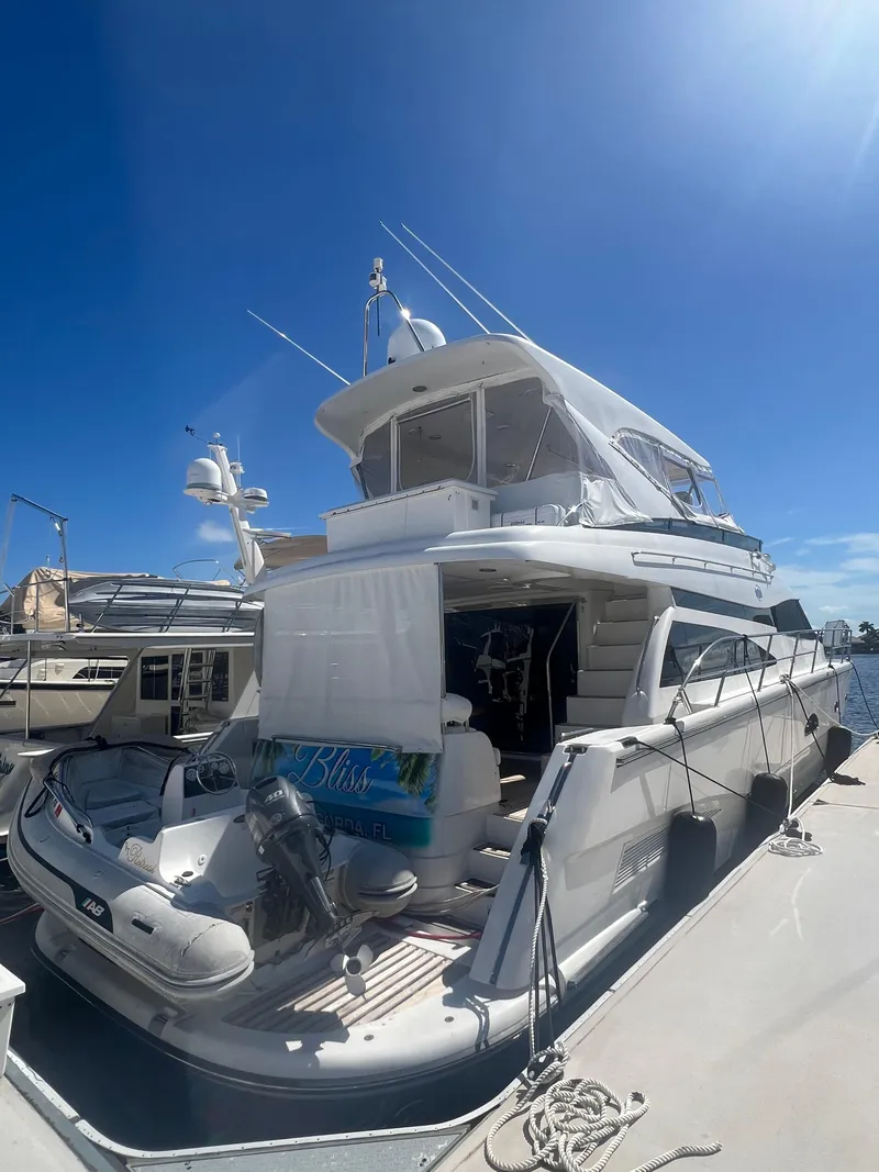 Slide: The Image of 2005 Neptunus 62 Flybridge yacht docked under clear blue sky. - 2