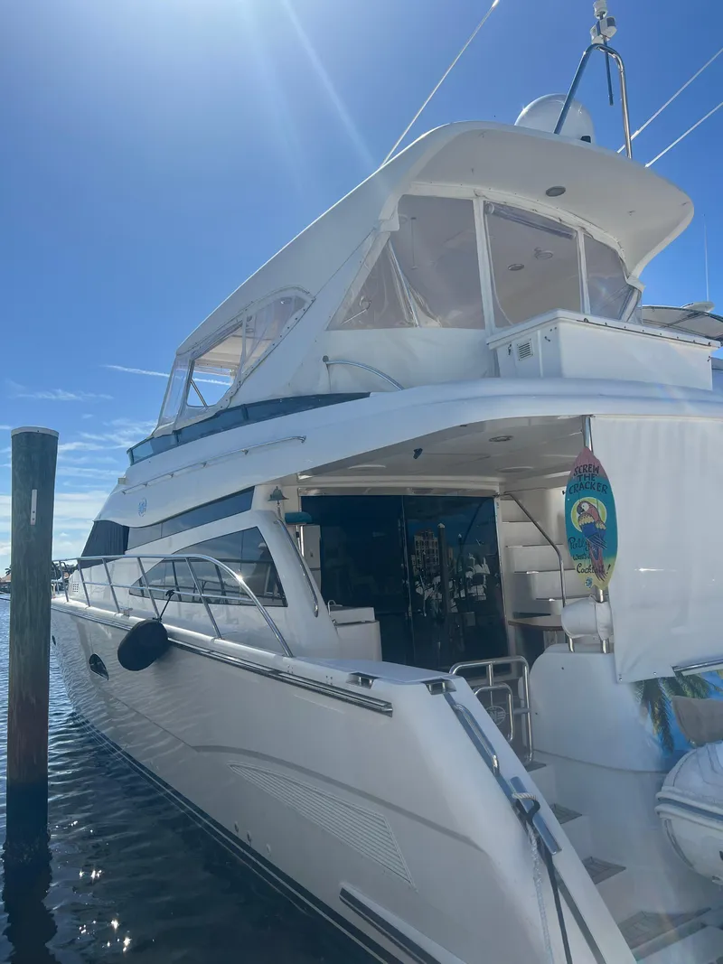 Slide: The Image of 2005 Neptunus 62 Flybridge yacht docked under clear blue sky. - 3