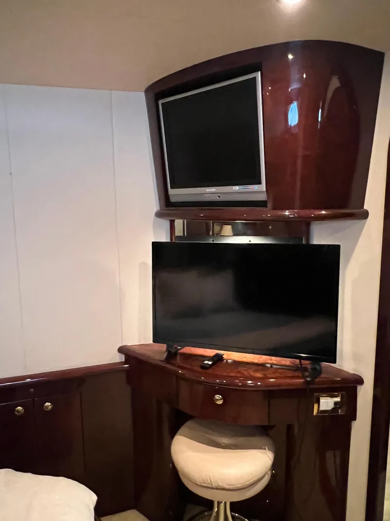 Slide: The Image of Luxurious 2005 Neptunus 62 Flybridge yacht interior with dual TVs and elegant wood finish. - 38