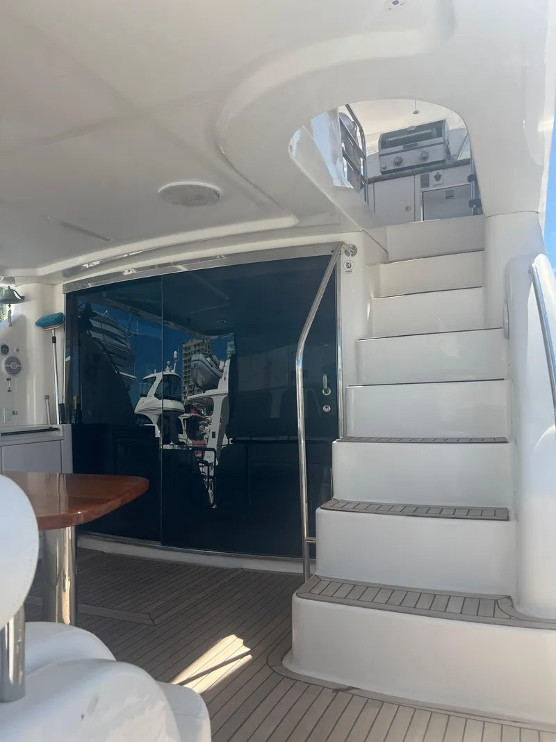 Slide: The Image of 2005 Neptunus 62 Flybridge yacht interior with stairs and seating area. - 4