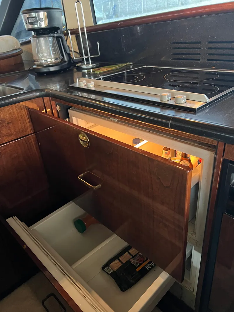 Slide: The Image of 2005 Neptunus 62 Flybridge yacht kitchen with stove, fridge, and coffee maker. - 49