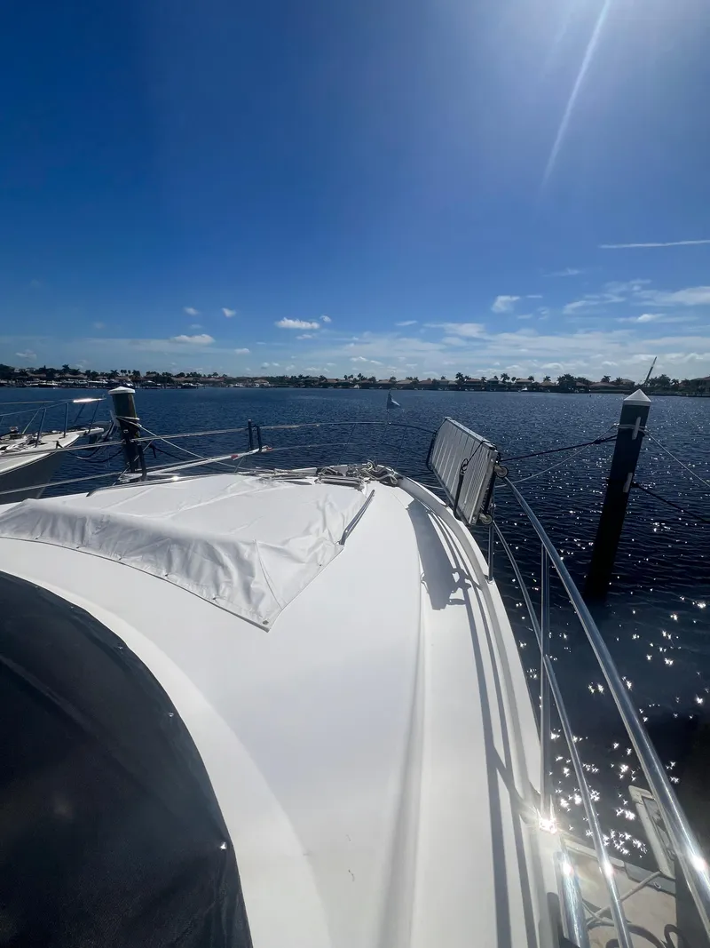 Slide: The Image of 2005 Neptunus 62 Flybridge yacht on a sunny day, overlooking calm waters. - 8