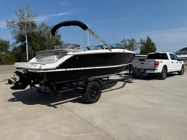 Slide: The Image of 2025 Four Winns H1 boat on trailer, parked outdoors with a white truck. - 3