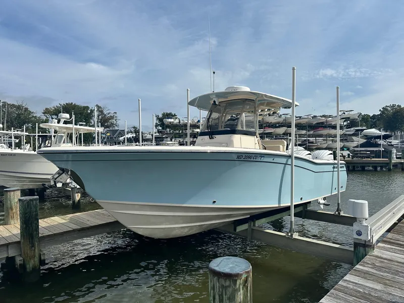 Slide: The Image of 2022 Grady-White Canyon 271 boat docked at marina, light blue hull, sunny day. - 0