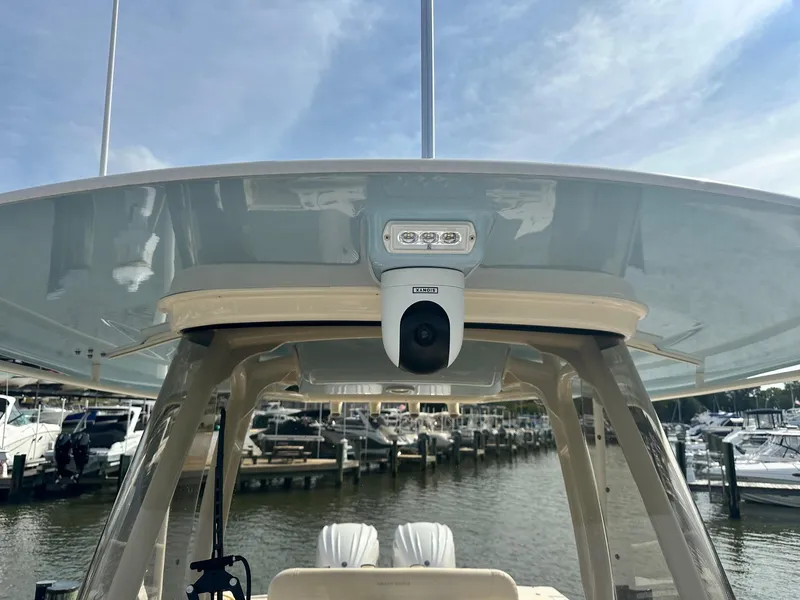 Slide: The Image of 2022 Grady-White Canyon 271 boat with camera, docked at marina under blue sky. - 11