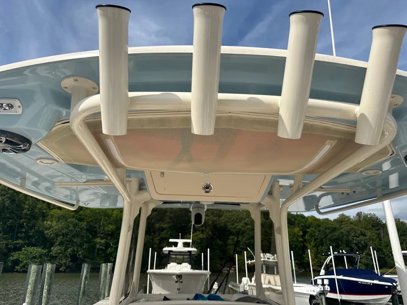 Slide: The Image of 2022 Grady-White Canyon 271 boat with rod holders, docked under a clear sky. - 8