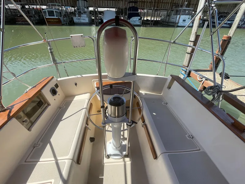 Slide: The Image of Cockpit of 1992 Island Packet 32 sailboat with steering wheel and seating. - 11
