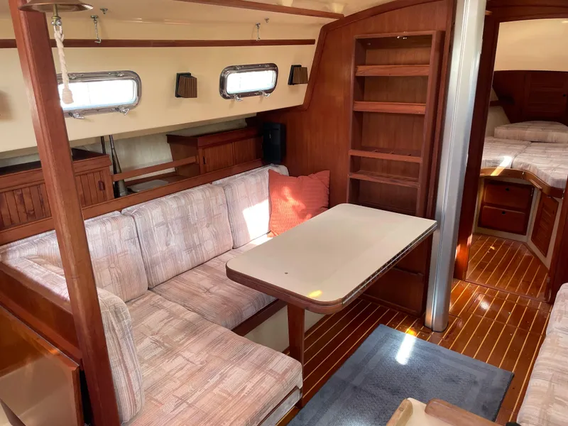 Slide: The Image of Interior of 1992 Island Packet 32 sailboat with cozy seating and wooden finishes. - 16