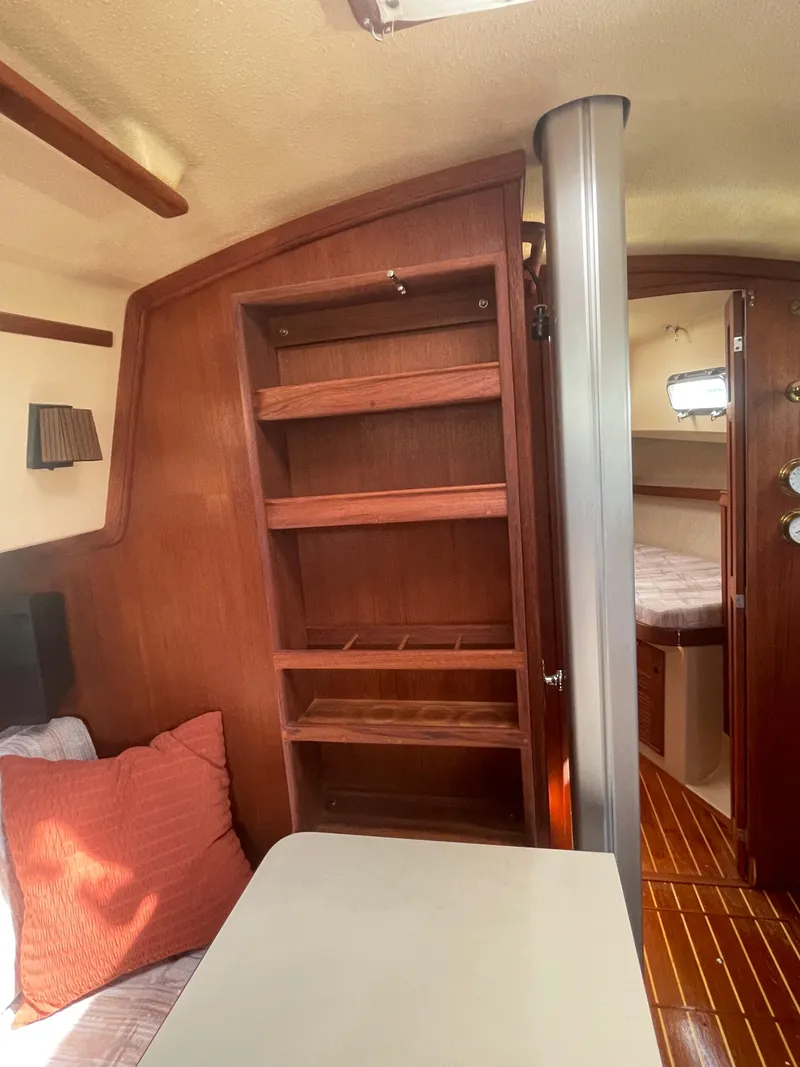 Slide: The Image of Interior of a 1992 Island Packet 32 sailboat with wooden shelves and cozy seating. - 17